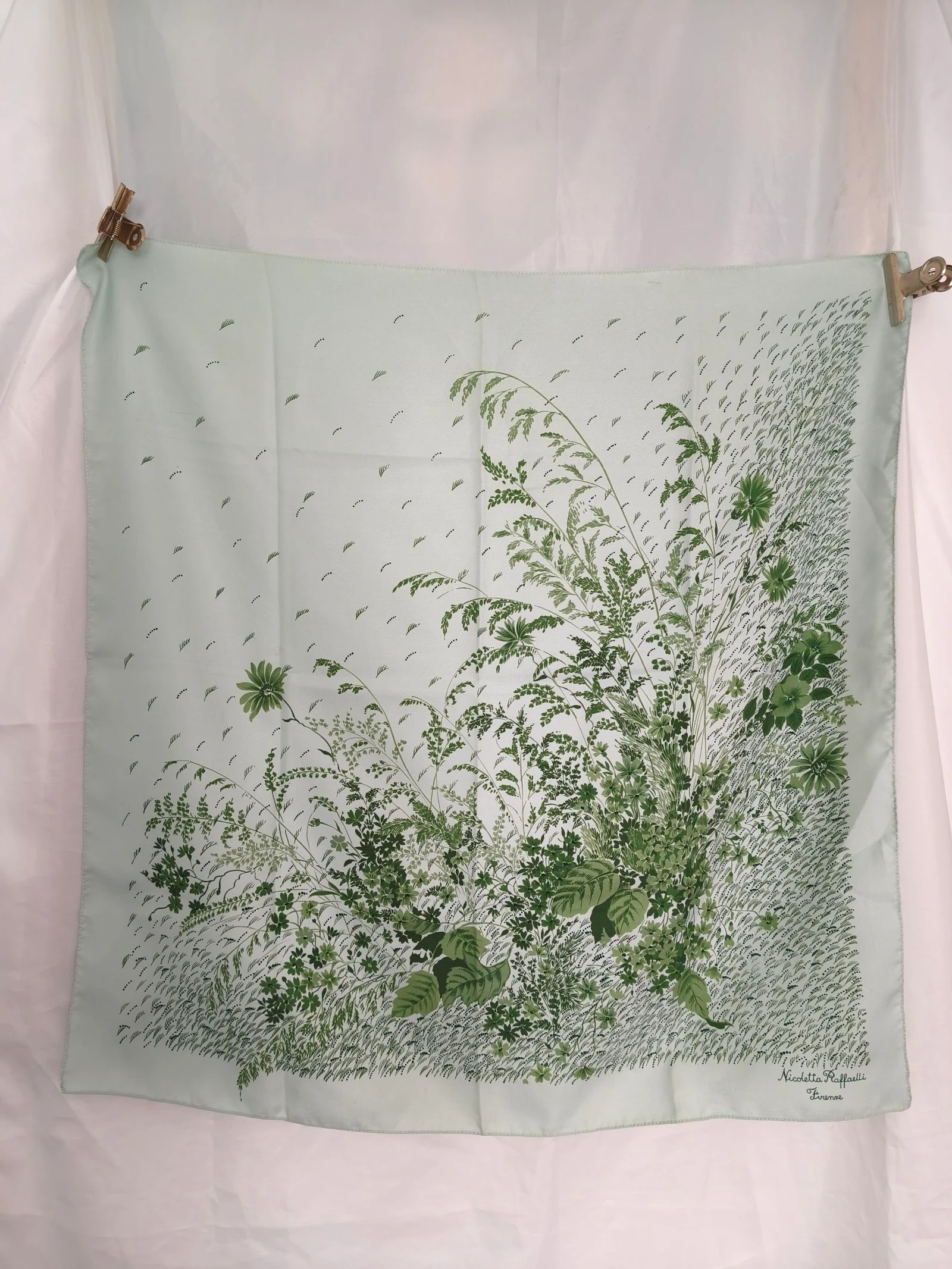 Lenço verde com estampa floral e de folhagens em tons de verde.